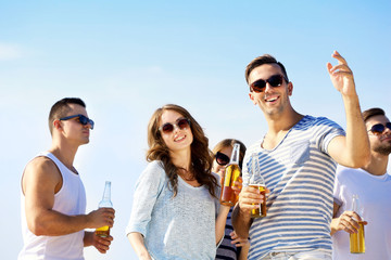 Young people with beer on the riverside