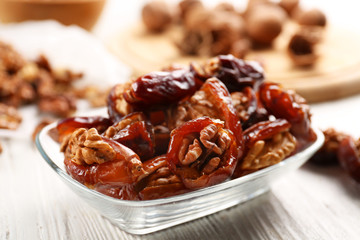 Walnut and date fruit on wooden table, close-up