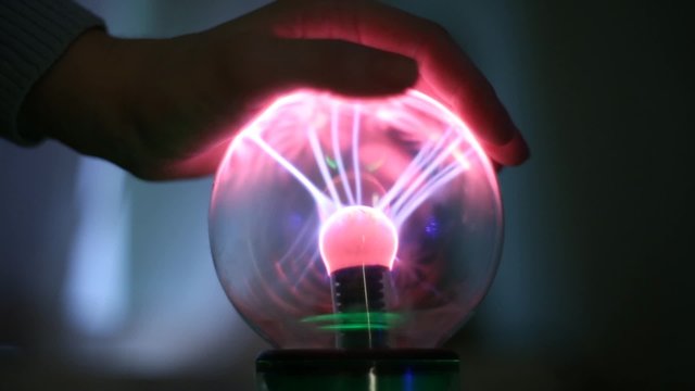 People touching hands of a lightning magic ball
