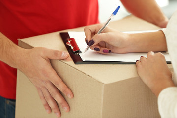 Woman signing receipt of delivery package, close up