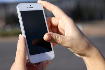 Woman holding smartphone outside