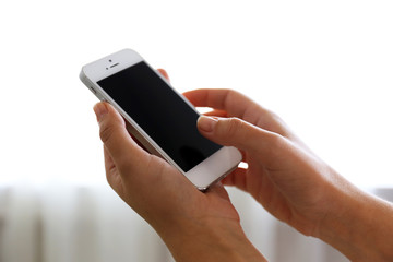 Woman holding smartphone indoors