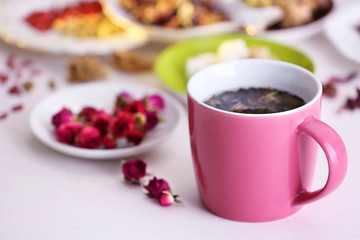 Cup of tea with aromatic dry tea on wooden background
