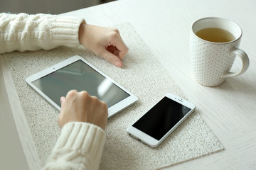 Woman using digital tablet on table close-up