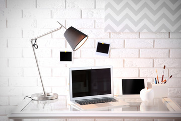 Modern workplace on brick wall background