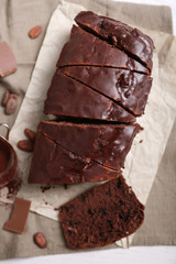 Chocolate sliced cake with icing on on tablecloth