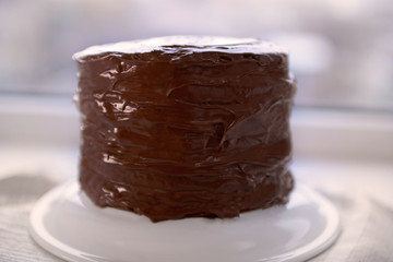 Chocolate cake on a plate on unfocused background