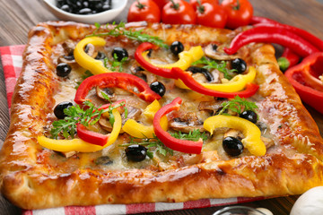 Freshly homemade pizza on wooden table closeup