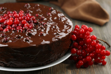 Chocolate cake with cranberries on wooden table, closeup