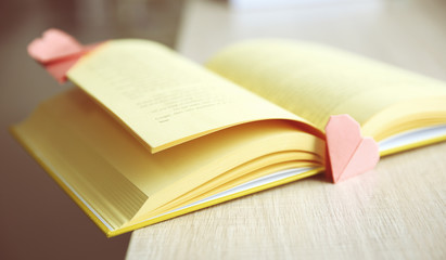 Book and heart shaped bookmarks on a wooden table