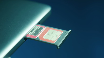 Two SIM cards in the slot in the cell phone placed on a blue background