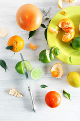 Fresh citrus fruits with green leaves on wooden table closeup