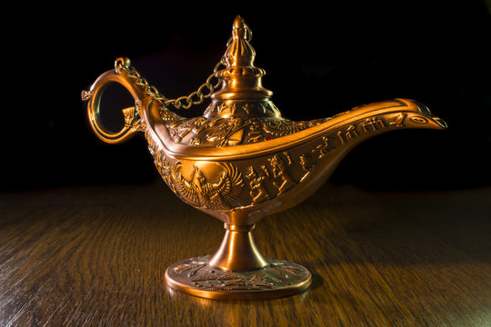 Aladdin's lamp isolated on wood background 