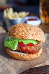 Big tasty hamburger on a paper, close up