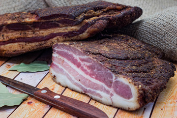 smoked meat with spices on a wooden board