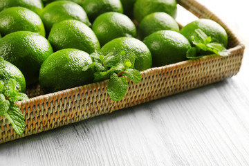 Wicker basket of limes on table