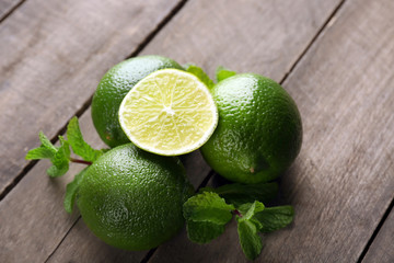 Limes with mint on wooden table