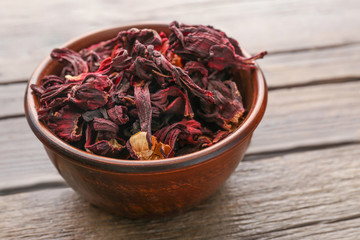 Hibiscus tea in a round bowl on wooden table, close up