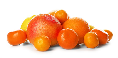 A heap of mixed citrus fruit including a grapefruit, oranges, lemons, clementines, tangerines, limes and a pomelo fruit isolated on a white background, close up