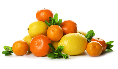 A heap of mixed citrus fruit including   lemons and tangerines with mint sprigs isolated on a white background, close up