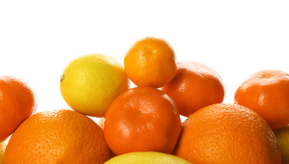 A heap of mixed citrus fruit including   lemons, tangerines, oranges isolated on a white background, close up