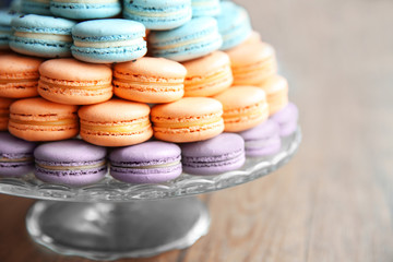 Many varicolored tasty macaroons on a dish, close up