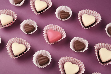 Tasty candies for Valentines Day on purple background