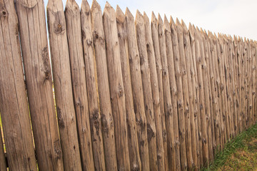 high old wooden fence of logs in form of palisade 