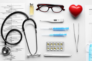 Doctor table with medicines, stethoscope and glasses, top view