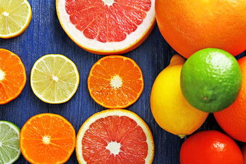 Juicy composition of sliced citrus on blue wooden background