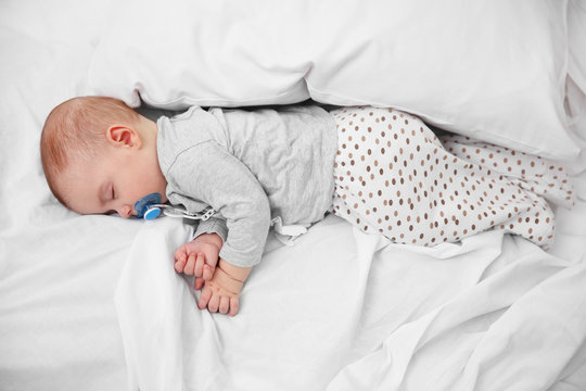 Loving Baby With Dummy Sleeping On Soft Bed, Close Up