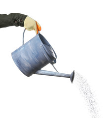 Hand pouring from metal watering can, isolated on white