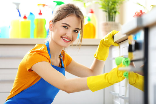 Cleaning concept. Woman washes an oven, close up