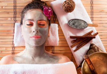 Mud Mask On Face With Cinnamon And Tibetan Singing Bowl
