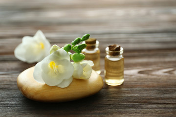 Fototapeta na wymiar Beautiful flower, aroma oil and candles on wooden background