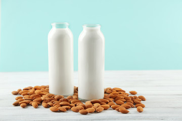 Bottles with milk and almond nuts on blue napkin