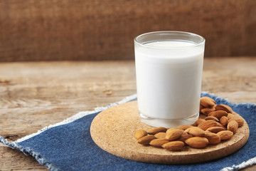 Cup of milk and almond nuts on table
