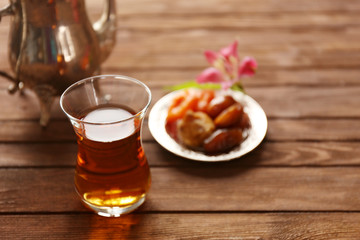 Glass of tea with dried fruits on wooden background