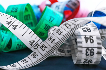 Colorful measuring tapes on a black background