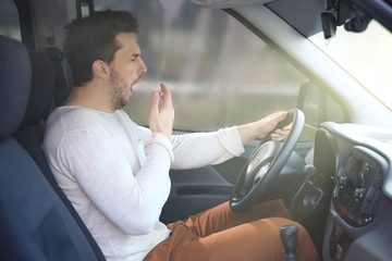 Tired young man driving his car.