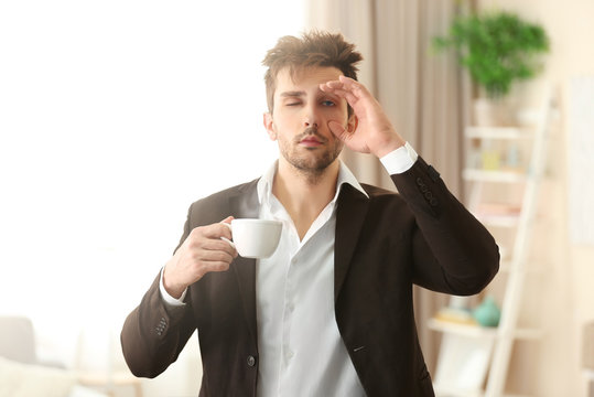 Sleepy guy holding a cup of coffee.