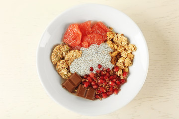 Chia seeds pudding with fruits, cookies and chocolate on light wooden background