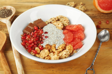 Chia seeds pudding with fruits, cookies and chocolate on wooden background