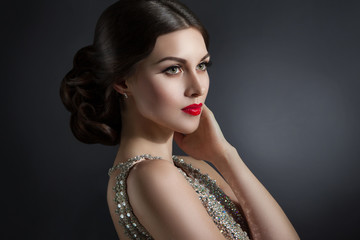 Beautiful young woman in an evening dress crystal. Perfect beauty, red lips, bright makeup. Twinkling sparkling stones on dress