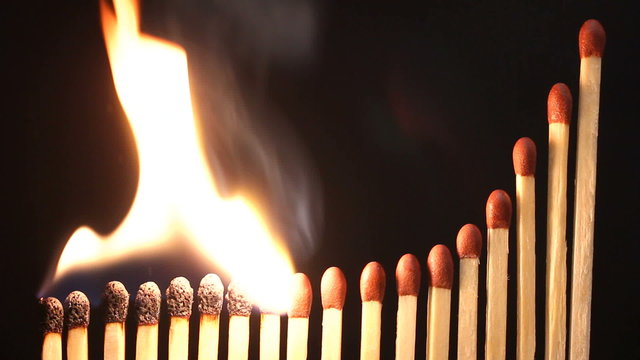 Curved rising line of matches bursting into flame and burning in sequence from the lowest. A chain reaction.