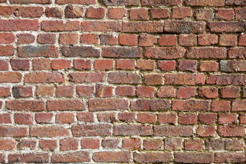 Obraz premium Hintergrundbild einer sanierungsbedürftigen texturierten Ziegelstein-Wand 