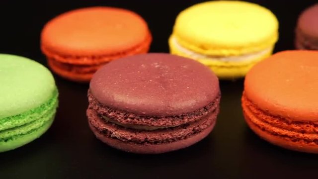 TRACKING: A rows of a colorful macaroons is on the black table
