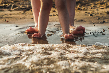 Mother and baby feet at the beach sand