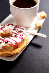 Glazed donut and coffee on the  black background