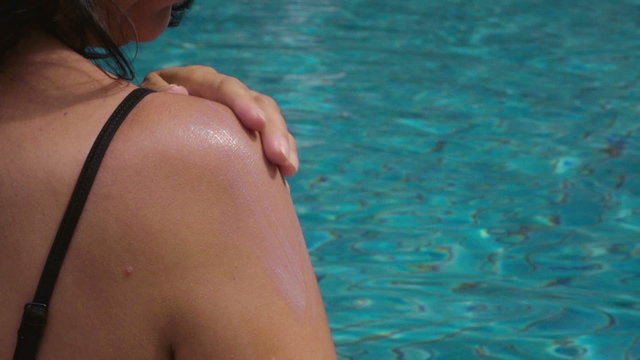 slow motion video of a Woman Applying Sun Cream at the swimming pool
